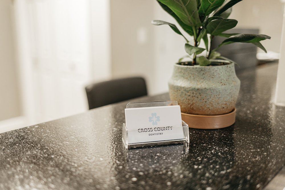 Cross County Dentistry business card displayed at the front desk in North Charleston, SC