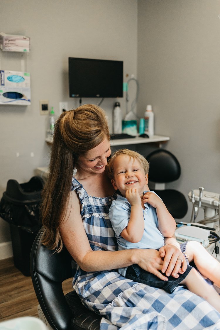 Happy child sitting with mother during a dental visit at Cross County Dentistry in North Charleston, SC