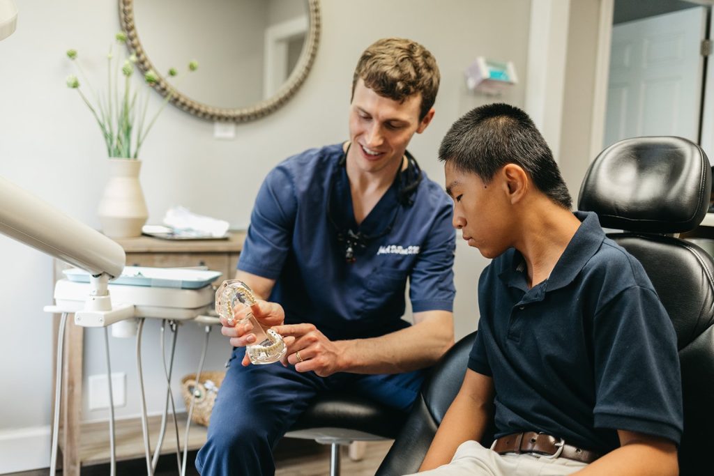 Dr. John DuRant explaining a dental model to a young patient at Cross County Dentistry in North Charleston, SC