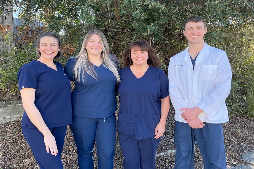 Dr. John DuRant and the Cross County Dentistry team smiling outside the office in North Charleston, SC